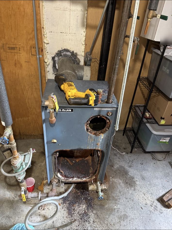 Old rusted boiler being cut apart for removal